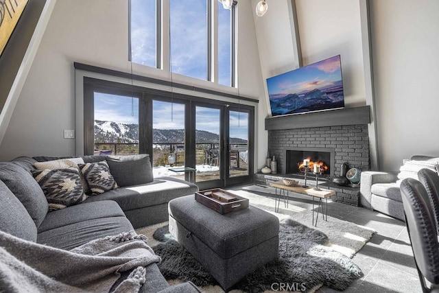 living area with a brick fireplace and a high ceiling