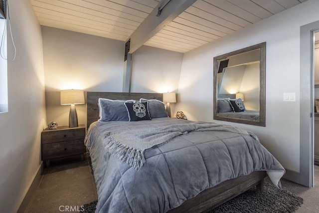 bedroom featuring wooden ceiling, baseboards, dark colored carpet, and beam ceiling