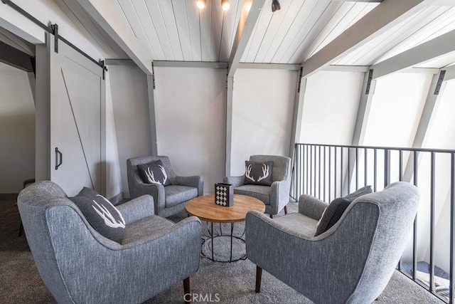 sitting room with beam ceiling and a barn door