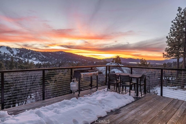 snow covered deck with a mountain view and area for grilling