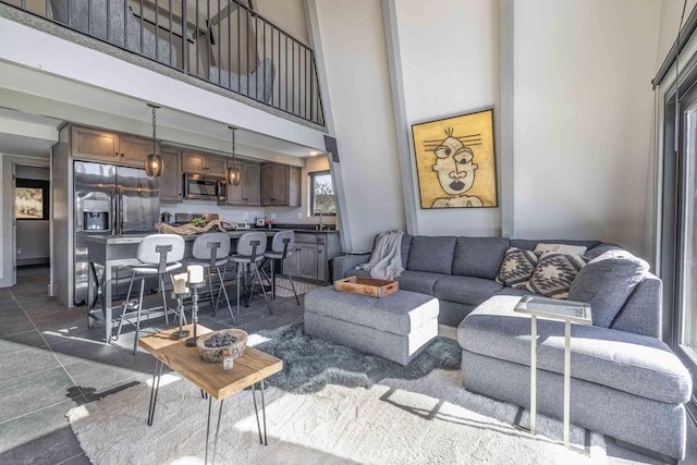 living room with a high ceiling and dark tile patterned flooring