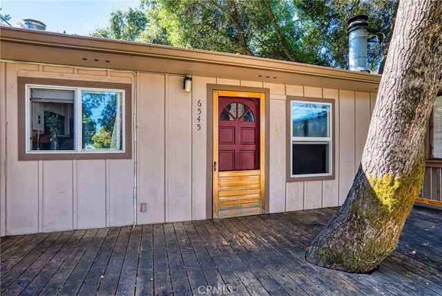 property entrance with a deck and board and batten siding