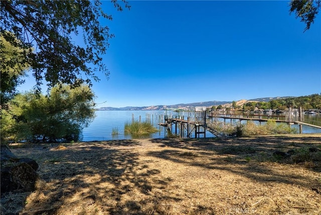 dock area featuring boat lift and a water and mountain view