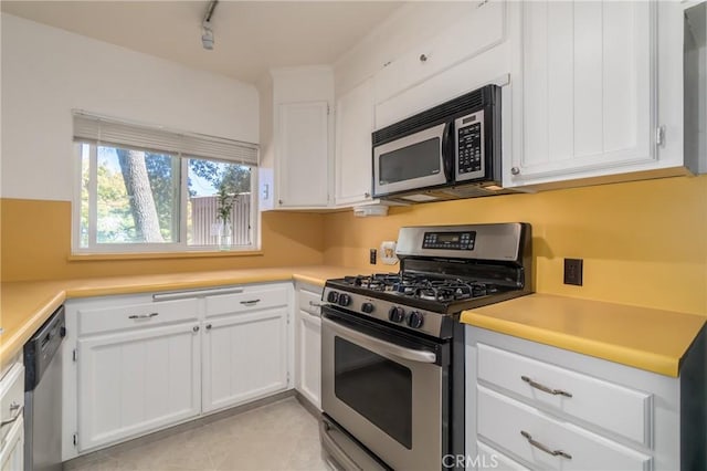 kitchen with stainless steel appliances, light countertops, and white cabinetry