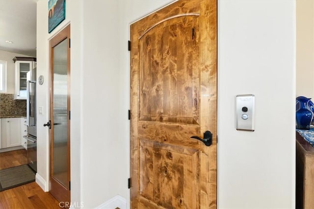 interior space with wood finished floors, oven, and baseboards