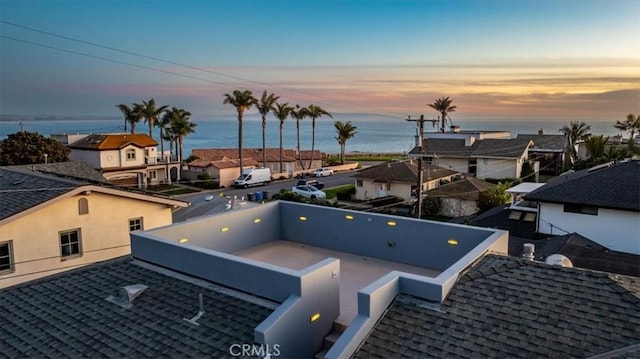 aerial view at dusk featuring a water view