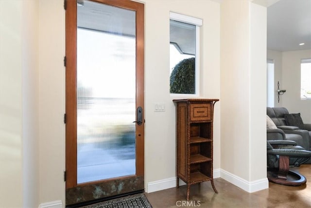 entrance foyer featuring baseboards and finished concrete floors