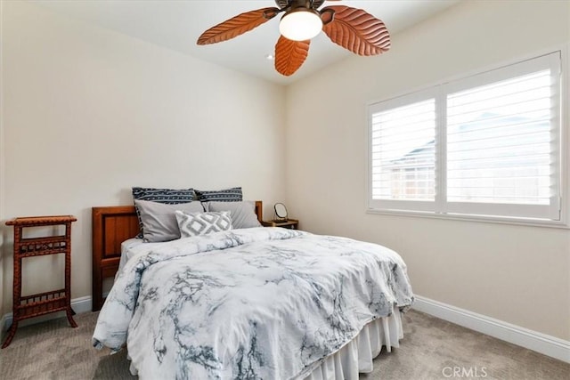 bedroom with baseboards, a ceiling fan, and light colored carpet