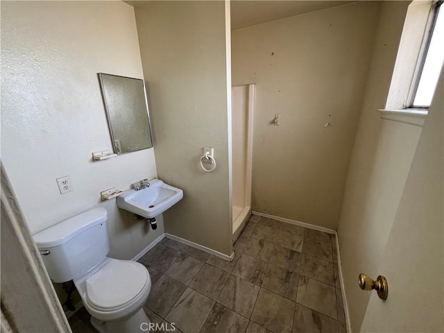 full bathroom featuring toilet, baseboards, and a sink