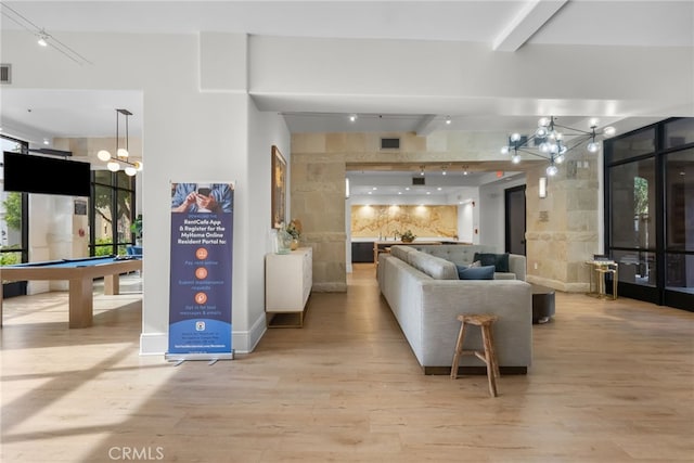 living area featuring a notable chandelier, billiards, expansive windows, light wood finished floors, and beamed ceiling