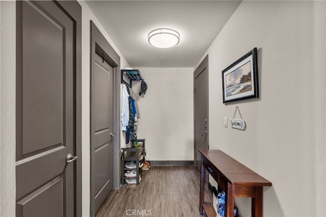 mudroom with wood finished floors and baseboards