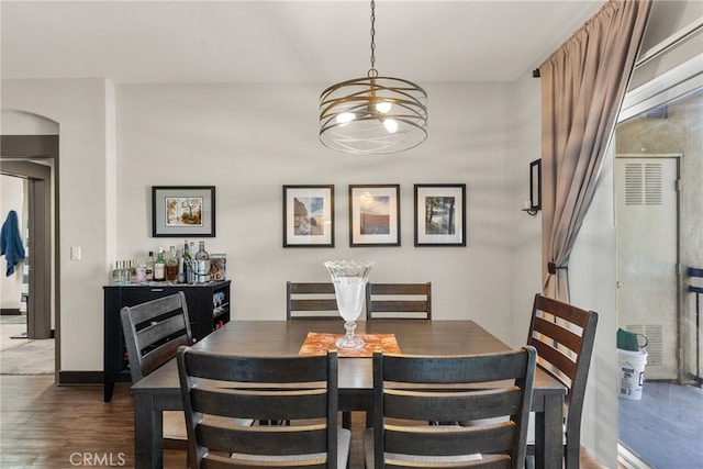 dining area featuring baseboards and dark wood-type flooring