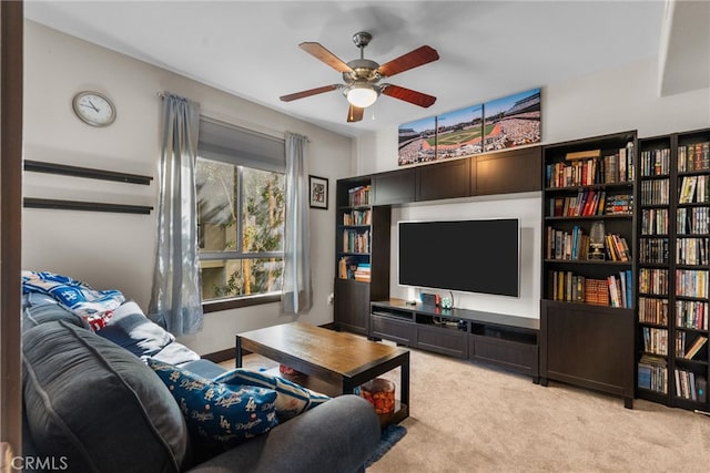 living area with a ceiling fan and light carpet