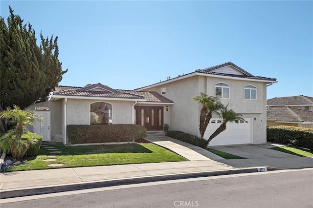 view of front facade with an attached garage, a tiled roof, concrete driveway, and stucco siding