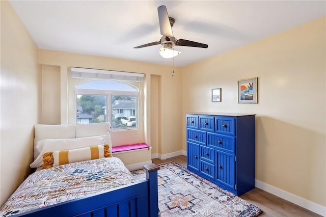 bedroom featuring light wood-style floors, baseboards, and a ceiling fan