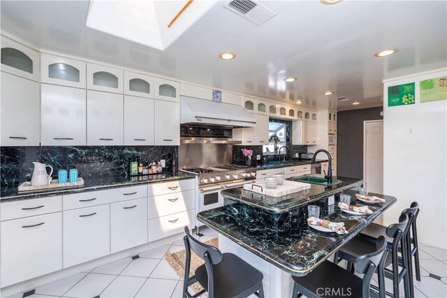 5726 Sunmist Dr, Rancho Palos Verdes, CA 90275 - kitchen with a sink, a kitchen bar, tasteful backsplash, range with two ovens, and light tile patterned floors