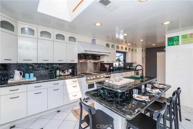 5726 Sunmist Dr, Rancho Palos Verdes, CA 90275 - kitchen with exhaust hood, double oven range, tasteful backsplash, a kitchen bar, and light tile patterned flooring