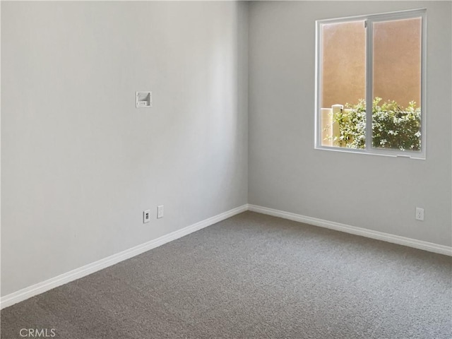 carpeted empty room featuring baseboards