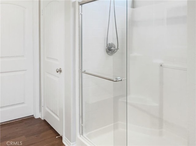 bathroom featuring a stall shower and wood finished floors