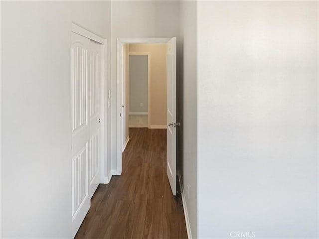 hall featuring baseboards and dark wood finished floors