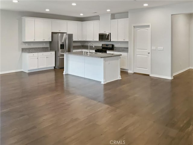 kitchen featuring stainless steel appliances, recessed lighting, white cabinets, and an island with sink