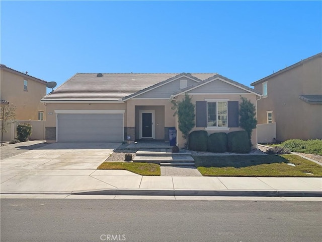 view of front facade with a tile roof, stucco siding, an attached garage, fence, and driveway