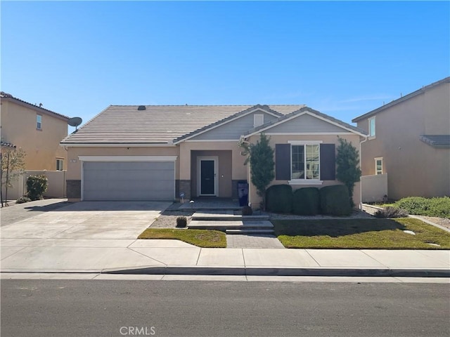 view of front of property with an attached garage, fence, a tile roof, concrete driveway, and stucco siding