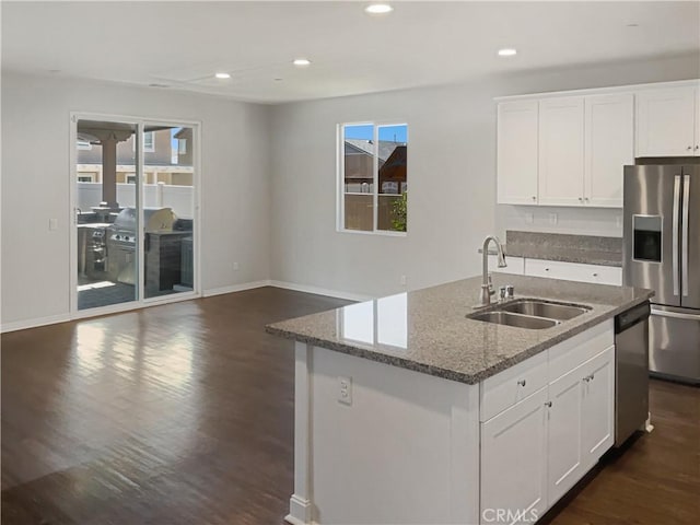 kitchen featuring appliances with stainless steel finishes, an island with sink, a sink, and white cabinetry