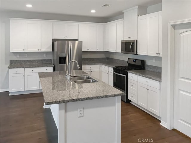 kitchen featuring stainless steel appliances, a sink, a kitchen island with sink, and white cabinets