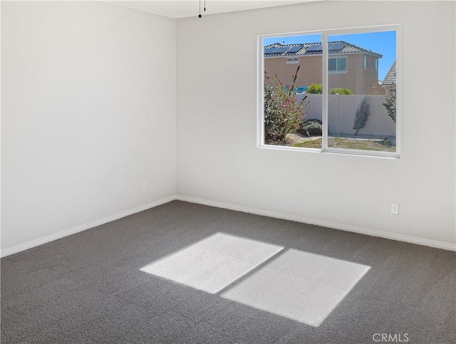 empty room featuring carpet flooring and baseboards