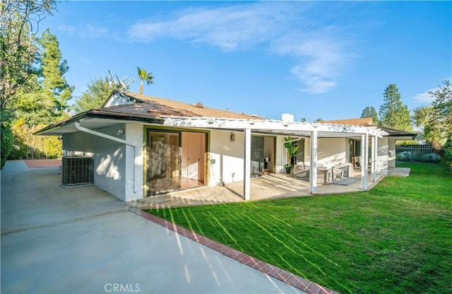 back of property with a lawn, a patio area, fence, and stucco siding