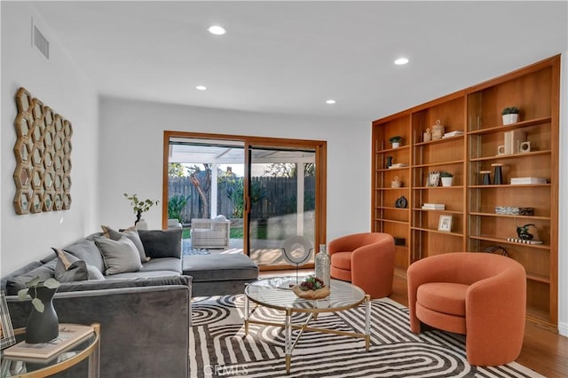 living area with dark wood-style flooring, visible vents, and recessed lighting