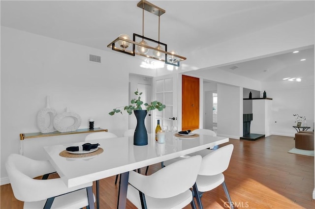 dining area with visible vents, baseboards, and wood finished floors