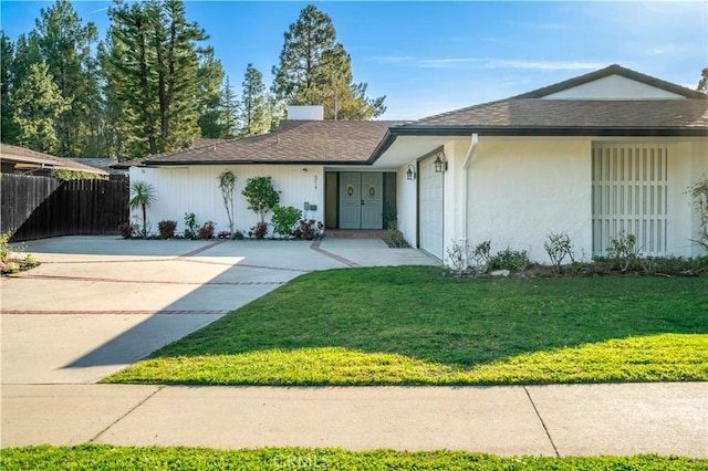 ranch-style home with driveway, an attached garage, fence, and a front yard