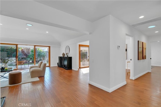 unfurnished living room with a wealth of natural light, light wood-style flooring, and baseboards