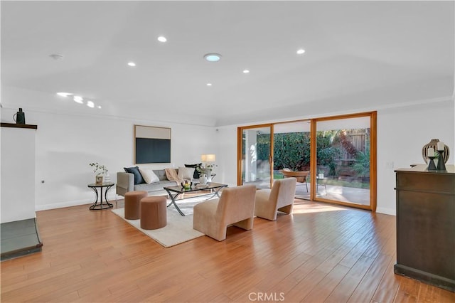 living area featuring light wood finished floors, baseboards, and recessed lighting