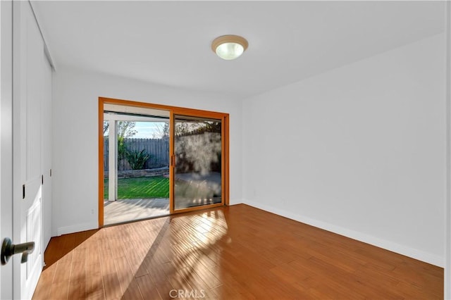 unfurnished room featuring baseboards and wood finished floors