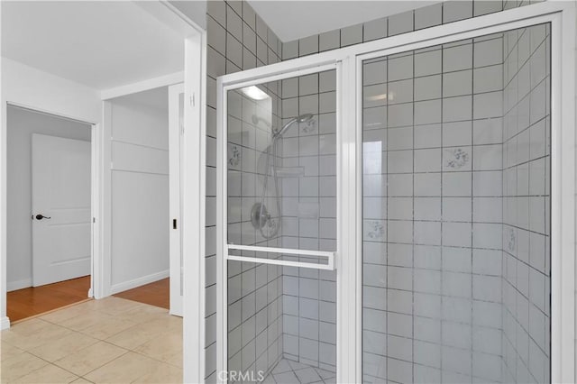 bathroom featuring a shower stall and baseboards