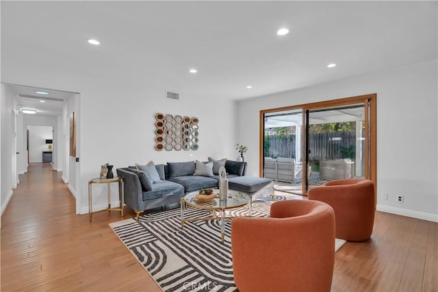 living room with recessed lighting, visible vents, light wood-style flooring, and baseboards