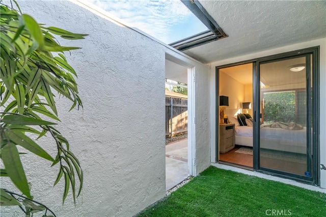 exterior space featuring a yard, fence, and stucco siding