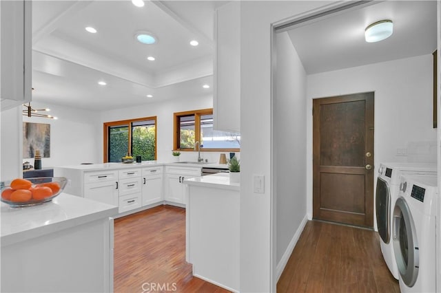 clothes washing area featuring recessed lighting, laundry area, a sink, wood finished floors, and independent washer and dryer