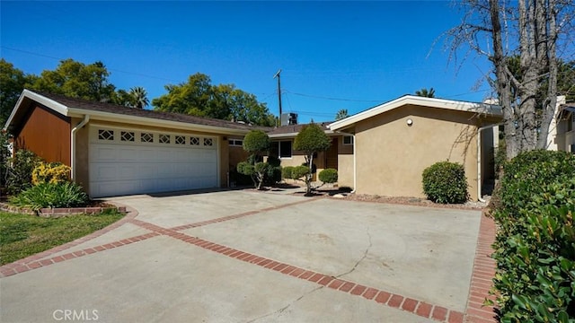 ranch-style home featuring an attached garage, concrete driveway, and stucco siding