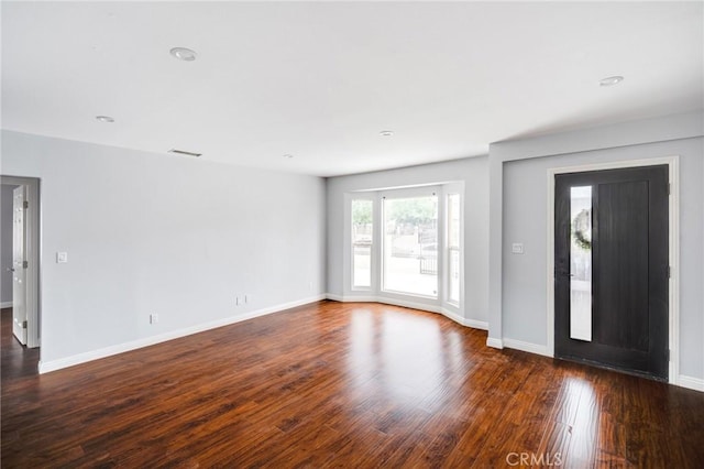 interior space with dark wood-type flooring and baseboards