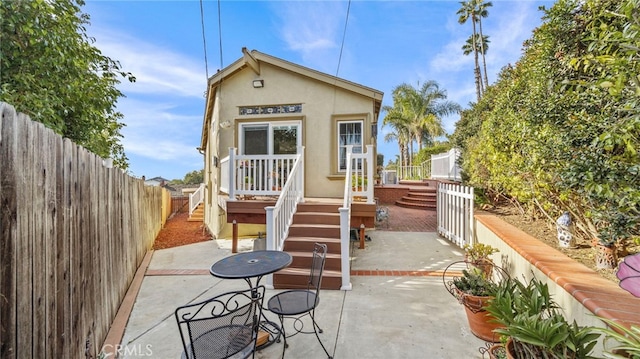 exterior space with stairs, a patio area, a fenced backyard, and stucco siding