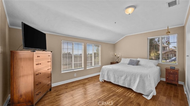 bedroom with multiple windows, visible vents, vaulted ceiling, and dark wood-style flooring