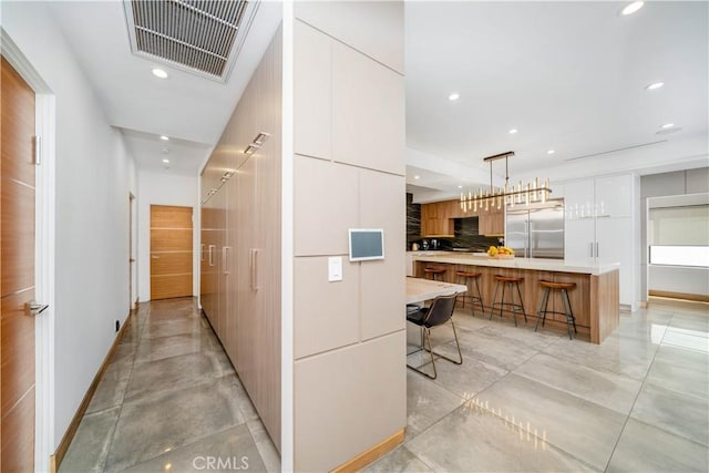 hallway featuring baseboards, visible vents, and recessed lighting