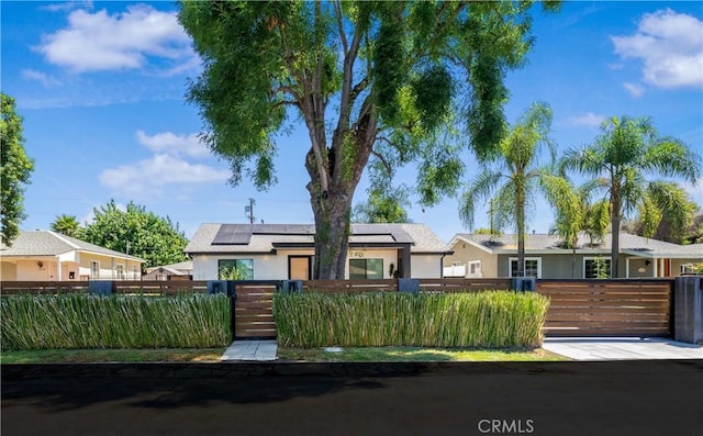 ranch-style home featuring a fenced front yard, a residential view, and stucco siding