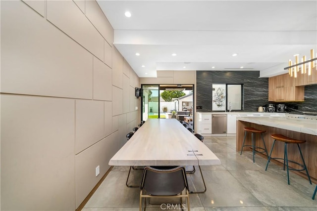 dining room with concrete flooring, recessed lighting, and tile walls