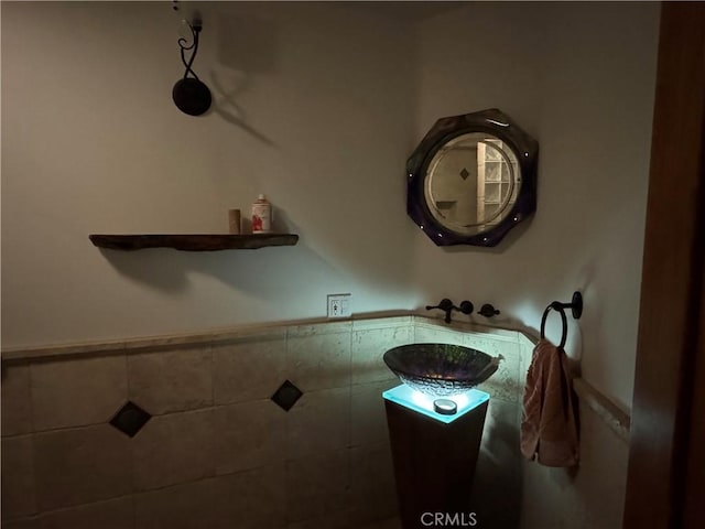 bathroom featuring wainscoting and tile walls