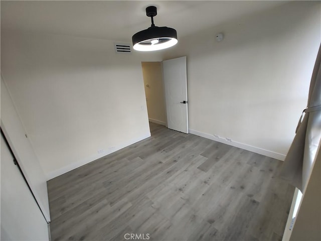 unfurnished dining area featuring light wood-type flooring, baseboards, and visible vents